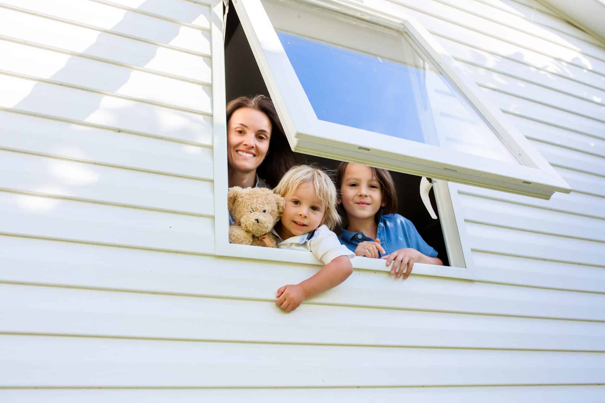 Mother and child, looking through window of mobile home